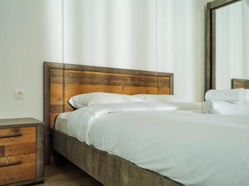 two beds in a bedroom with a wooden headboard at CloudView Studio - Aviatiei, Private Underground Parking in Bucharest