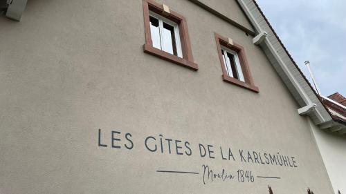 a building with two windows on the side of it at LES GITES DE LA KARLSMUHLE in Haguenau