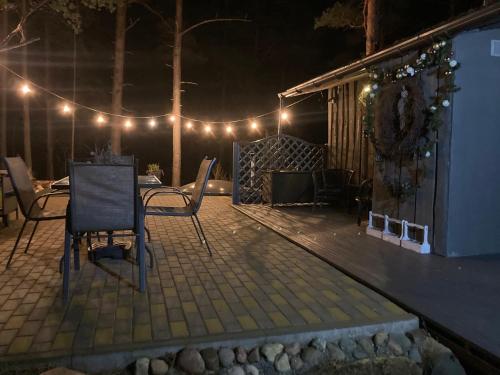 a patio at night with chairs and lights at Pie jūras in Klapkalnciems