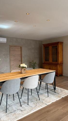 a dining room with a wooden table and chairs at LES GITES DE LA KARLSMUHLE in Haguenau