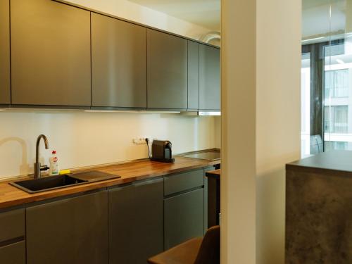 a kitchen with gray cabinets and a sink at CloudView Studio - Aviatiei, Private Underground Parking in Bucharest