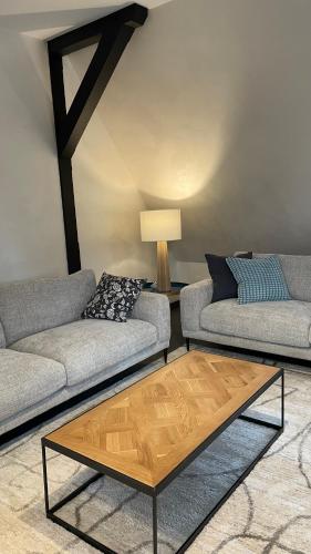 a living room with two couches and a coffee table at LES GITES DE LA KARLSMUHLE in Haguenau