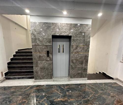 a hallway with a door in a building with stairs at Hotel Royal Palace Gaya in Gaya