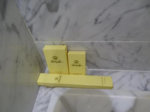 dos cajas amarillas sentadas en un estante en un baño en Comfort Inn Al Taawon - Family Only, en Riad