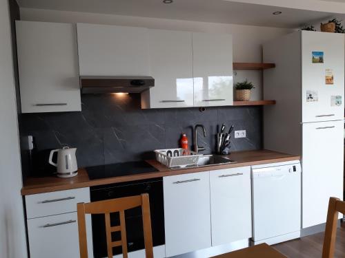 a kitchen with white cabinets and a sink at Beautiful Studio at Geneva airport Ferney Voltaire in Ferney-Voltaire