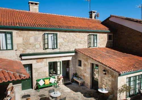 an old stone house with a red roof at Casa de Costoia in Santiago de Compostela