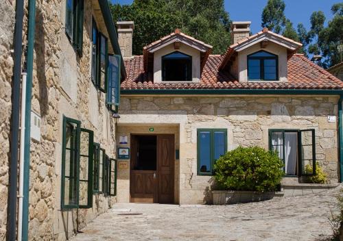 an old stone house with a door in a street at Casa de Costoia in Santiago de Compostela