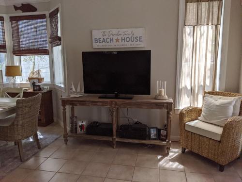 un soggiorno con TV a schermo piatto su un tavolo di SeaQuinn a Inlet Beach