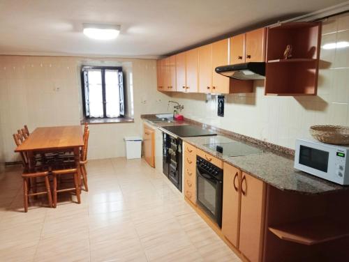 eine Küche mit einem Tisch und einer Arbeitsplatte in der Unterkunft Casa Pelayo 2 in Poo de Cabrales