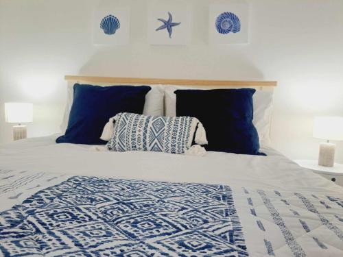 a bed with a blue and white comforter and pillows at Cliff Cottage in Valtos