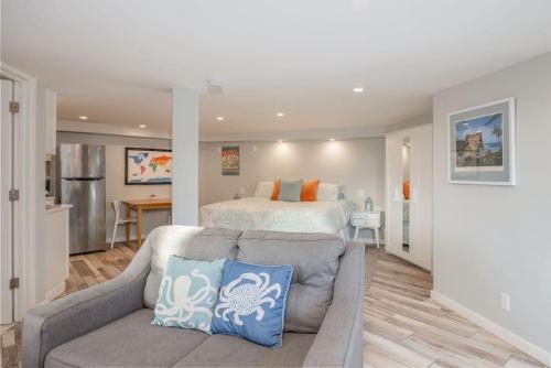 a living room with a bed and a couch in front of a bedroom at Coastal Zen Cottage - Walk To Beach in Half Moon Bay