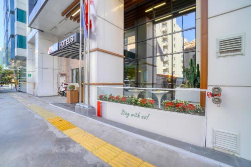 a sign on the side of a building with flowers in a window at İbos Hotels Izmir in Izmir