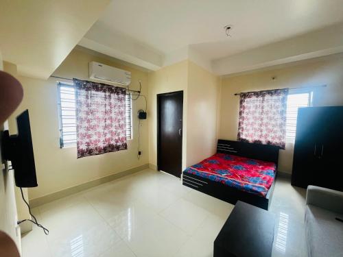 a small room with a bed and two windows at The Lakeview Apart-Hotel in Agartala