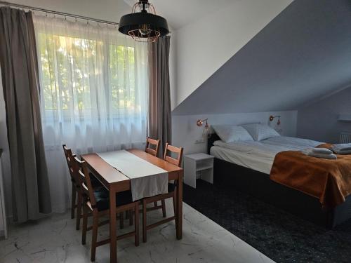 1 dormitorio con mesa, cama y ventana en Willa Biszkoptowa, 