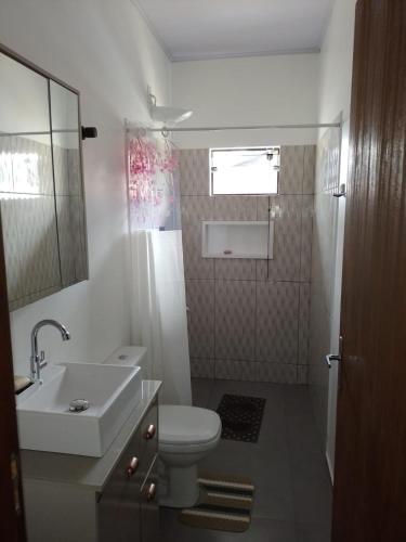 a bathroom with a white toilet and a sink at Casa Neumann in Penha