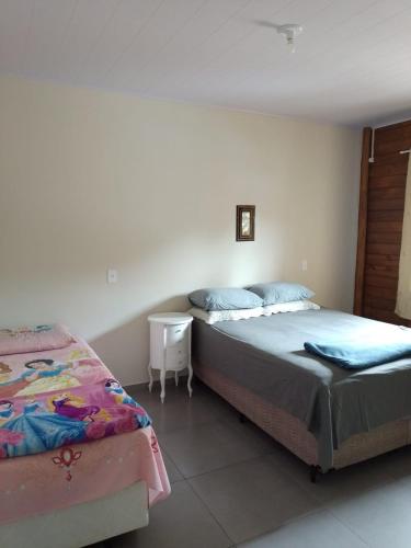 a bedroom with two beds and a table and a bed at Casa Neumann in Penha