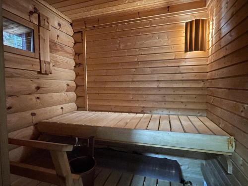a small wooden sauna with a bench in it at Villa Saimaa in Vuoriniemi