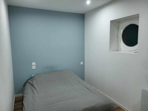 a room with a bed and a wall with a window at Place du Canada 2 in Valenciennes