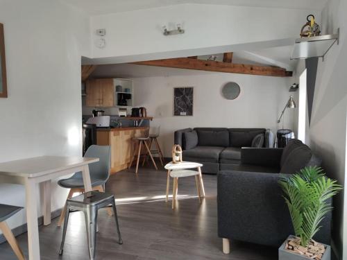 a living room with a couch and a table at Escale à Clisson - La Parenthèse in Clisson