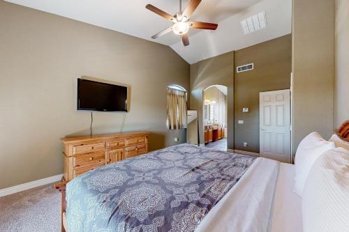 a bedroom with a bed and a flat screen tv at Desert Sanctuary in Litchfield Park