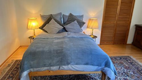 a bedroom with a large bed with two lamps at hAUSzeit - Bungalow in Leoben