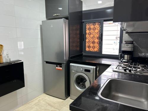 a kitchen with a refrigerator and a washing machine at Adrarhost in Agadir