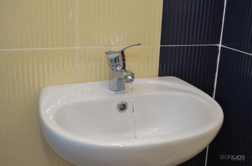 La salle de bains est pourvue d'un lavabo blanc et d'un robinet. dans l'établissement NAREK B&B, à Goris