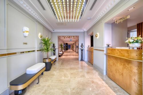 a corridor of a salon with benches in a lobby at İbos Hotels Izmir in Izmir
