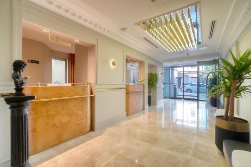 a lobby with a reception desk and a potted plant at İbos Hotels Izmir in Izmir