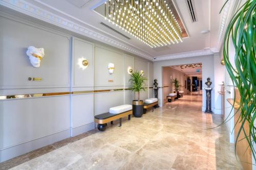 a lobby of a building with benches and plants at İbos Hotels Izmir in Izmir
