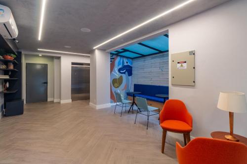 ein Büroflur mit Stühlen und einem Tisch und einem Wandgemälde in der Unterkunft 360 Praça da Árvore in São Paulo