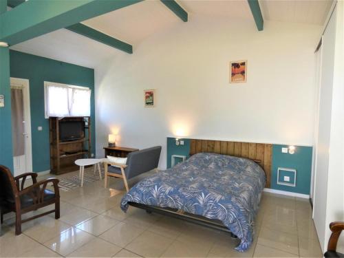 a bedroom with a bed and a desk and a chair at Les palombieres in Soustons