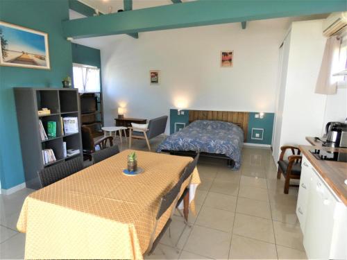 Cette chambre comprend un lit, une table et une cuisine. dans l'établissement Les palombieres, à Soustons