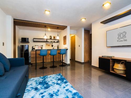 a living room with a blue couch and a bar at Edificio Piso 56 in Mexico City