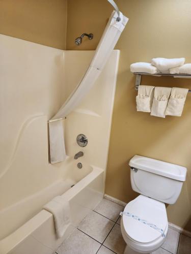 a bathroom with a toilet and a bath tub at Super 8 by Wyndham Pine Bluff in Pine Bluff