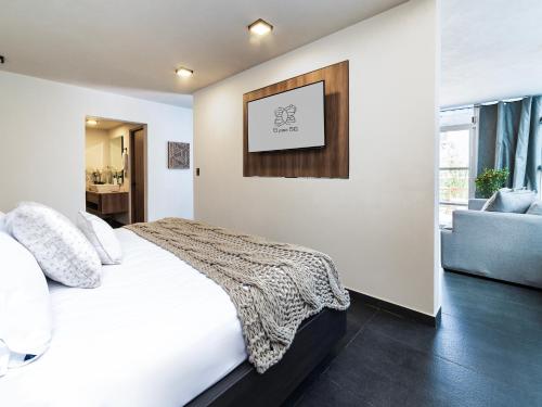 a bedroom with a white bed and a couch at Edificio Piso 56 in Mexico City