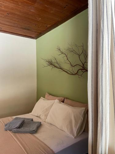 a bedroom with a bed with a tree painting on the wall at Casas Goiás - Suítes Beira Rio - Centro Histórico in Goiás