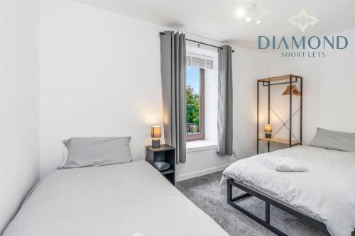a bedroom with two beds and a window at FOUNDRY - 2 Bedrooms, Fully Equipped, Free Parking, WiFi, FAVOURITE for Contractors, Long Stays Welcome, Food, Bars, Shops by Diamond Short Lets in Dunfermline
