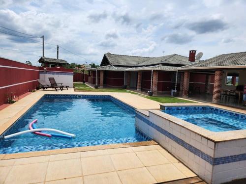 una piscina frente a una casa en Chácara Vale do Sol, en Pinhalzinho