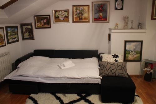 1 cama en un dormitorio con cuadros en la pared en Apartman Bony M, en Kiseljak