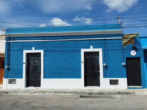 a blue building with two doors on a street at Casa Cuevas & Amaro in Mérida