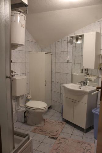 a bathroom with a toilet and a sink at Apartman Bony M in Kiseljak