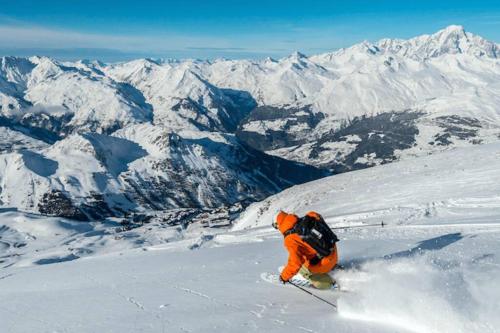 una persona está esquiando por una montaña cubierta de nieve en Joli Studio proche funiculaire en Bourg-Saint-Maurice
