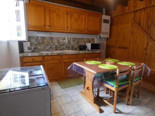 a kitchen with a wooden table with green plates on it at Gite bonnebat in Lacrabe
