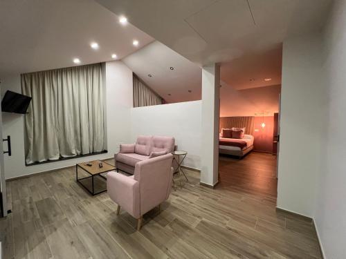 a living room with a pink chair and a couch at Casal de pelaio in Barreiros