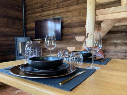 einen Tisch mit Tellern und Weingläsern darauf in der Unterkunft Chalet Amoureux (Région Durbuy) in Heure