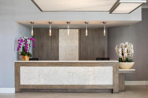 a reception desk in a lobby with flowers at Ocean View Hotel in Los Angeles