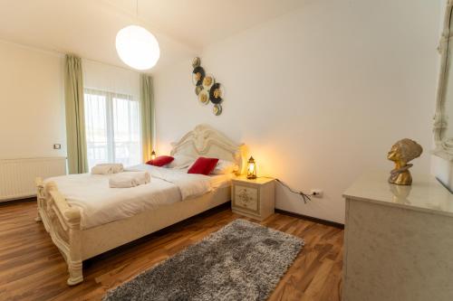a bedroom with a bed with white sheets and red pillows at Spacious 3 rooms 5* mansion near Muzeului square. Free parking in Cluj-Napoca