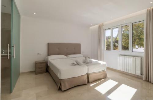 una camera bianca con un grande letto e finestre di Villa Can Luciana a La Aranjasa