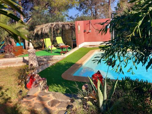 - une piscine dans une cour avec 2 chaises et une maison dans l'établissement BO-Piscine chauffée, Bénagil-Carvoeiro, à Carvoeiro
